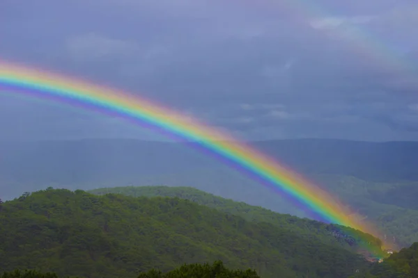Bright colorful rainbow after rain in the mountains in the tropics