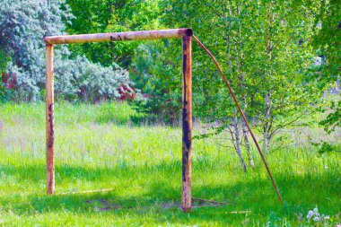 Terk edilmiş bir futbol sahasındaki paslı metal kapılar.