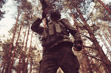 Ormandaki bir muharebe görevinde kamuflajlı genç bir özel kuvvet askeri.