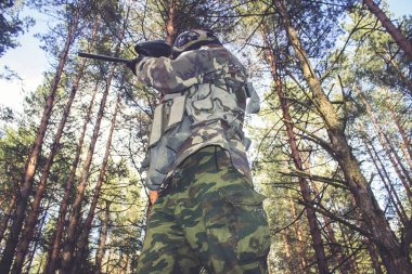Ormandaki bir muharebe görevinde kamuflajlı genç bir özel kuvvet askeri.