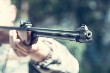 Genç bir nişancının elinde büyük bir spor tüfeği