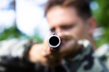 Genç bir nişancının elinde büyük bir av tüfeği.