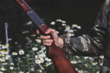 Genç bir nişancının elinde büyük bir av tüfeği.