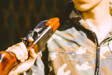 Genç bir nişancının elinde büyük bir av tüfeği.