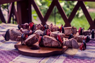 Piknikte şişe bağlanmış et, domates ve patlıcan parçaları.