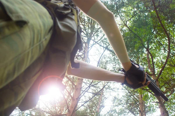 Siyah tabanca, maskeli genç bir özel kuvvetler askerinin elinde.