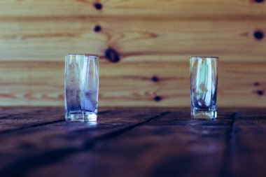 Ahşap bir kırsal masada cam bir bardak.