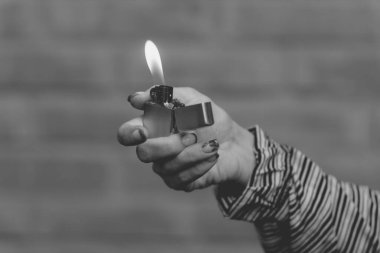 Genç bir kızın elinde eski bir Amerikan çakmağı