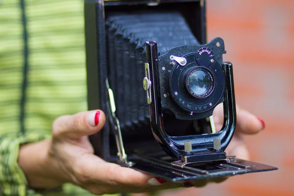 Old German retro camera in the hands of a young girl photographer