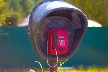Terk edilmiş bir köyde eski bir ankesörlü telefon.