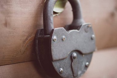 Eski demir menteşeli ahır eski kilidi, ahşap bir kapının üzerinde bir döngüyle kapandı.