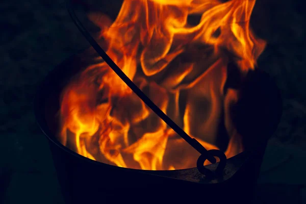 Orange blazing raging fire in a cast iron pot