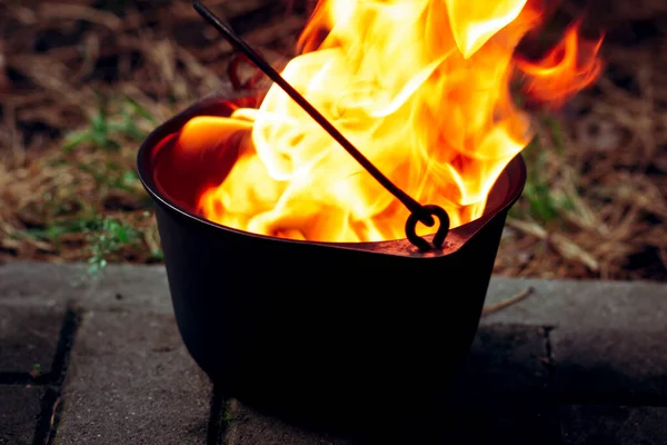 Orange blazing raging fire in a cast iron pot