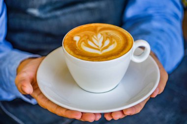 Kahve Kupası çiçek kahve Kupası ve kadın parmağında holding eller.