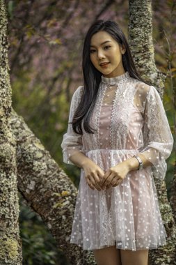 Güzel genç genç kız bir ağaçların altında poz.