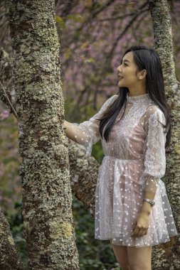 Güzel genç genç kız bir ağaçların altında poz.