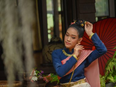 Lanna tarzı giyinmiş güzel kadınlar çiçek düzenliyor.