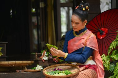 Lanna tarzı giyinmiş güzel kadınlar çiçek düzenliyor.