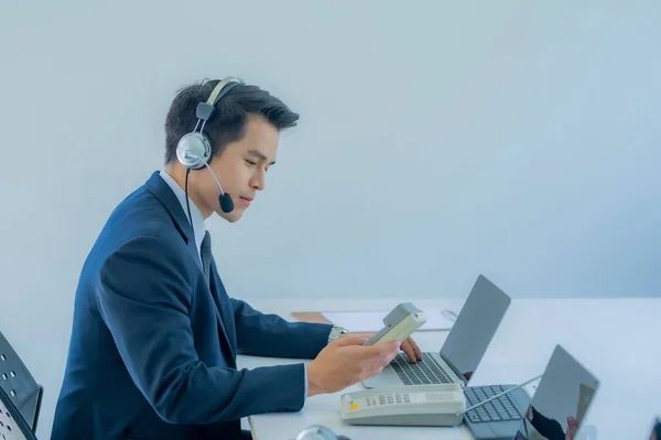 Portrait of confident male customer service representative with headset in call center.