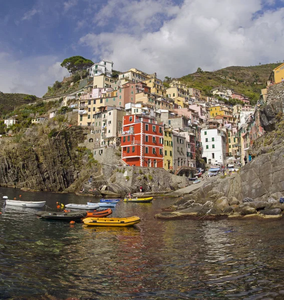 Small boats in Riomadzhore\'s harbor against the background of the houses and clear sky at solar noon