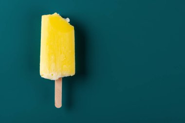 Lacivert bir arka plan üzerinde bir ısırık ile sarı buzlu şeker