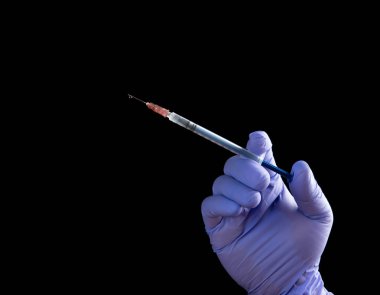 Tıbbi şırınga enjeksiyon siyah arka planda tutan el