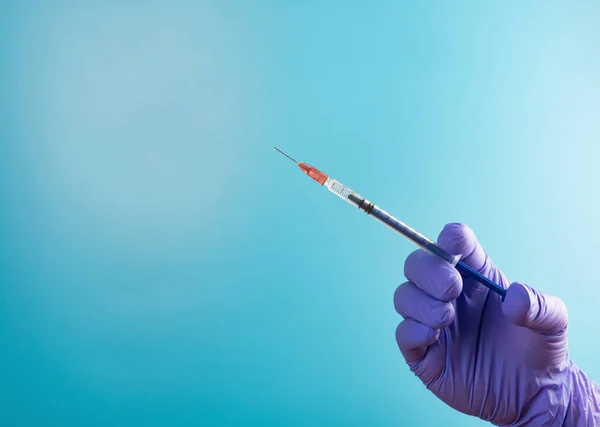 Mão Segurando Seringa Injeção Médica Fundo Azul — Fotografia de Stock