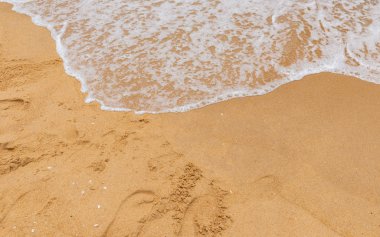 Kumlu bir sahilde yumuşak dalgalar