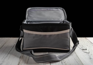 Önden Görünümü gri ve siyah paketi taşıyıcı üst açık siyah arka plan üzerine ahşap bir masa üzerinde öğle yemeği