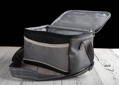 yan görünümü gri ve siyah paketi taşıyıcı üst açık siyah arka plan üzerine ahşap bir masa üzerinde öğle yemeği