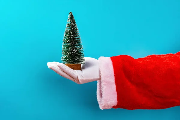 Santa Claus Houden Een Kerstboom Model Voor Een Blauwe Achtergrond — Stockfoto