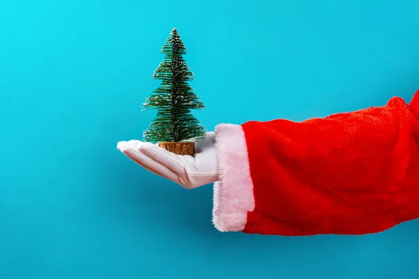 Santa Claus Houden Een Kerstboom Model Voor Een Blauwe Achtergrond — Stockfoto