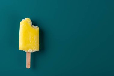 Lacivert bir arka plan üzerinde bir ısırık ile sarı buzlu şeker