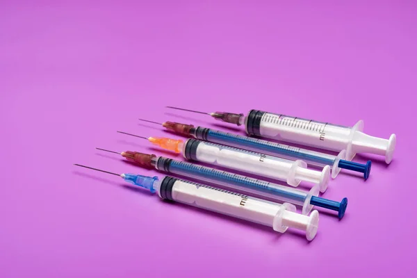 コピー スペースを持つ紫色の背景に注射器 — ストック写真