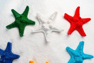 Multi renk starfishes beyaz kum üzerinde