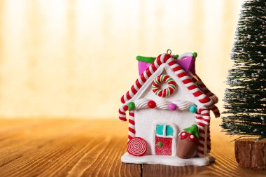 Noel evi ile parlak altın arka plan önünde köknar ağacı