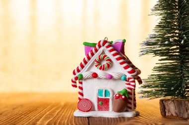 Noel evi ile parlak altın arka plan önünde köknar ağacı