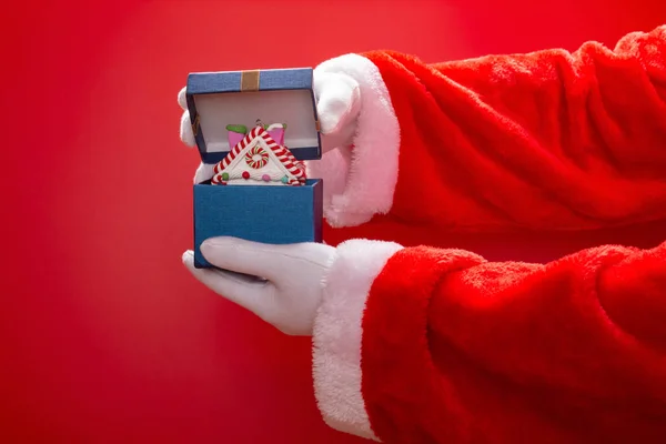 Santa Claus Otevření Krabičce Modelem Vánoční Dům Červeném Pozadí — Stock fotografie