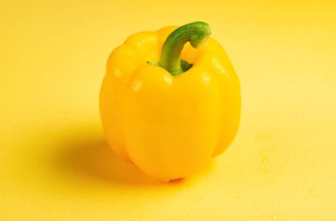 taze sarı dolmalık biber ile sarı bir arka plan üzerine damlar