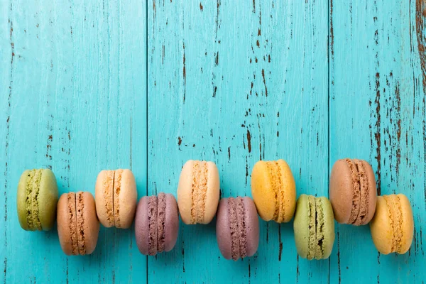 kopya alanı ile mavi bir arka plan üzerinde renkli macaroons satır yukarı stüdyo çekimleri
