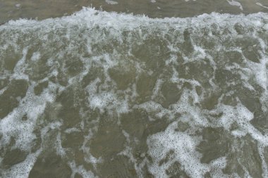 arka plan olarak bir kum plajındaki dalga