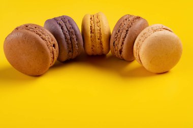 sarı arka plan üzerinde renkli macaroons satır yukarı stüdyo çekimleri kavisli