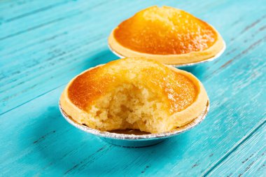 taze cocknut tarts ve mavi ahşap arka plan üzerinde bir ısırık ile yakın çekim