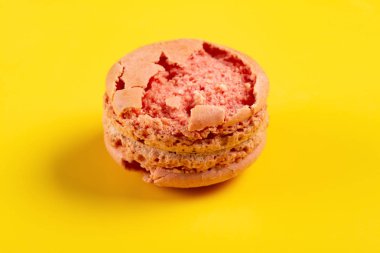 sarı arka plan üzerinde bozuk pembe acıbadem kurabiyesi