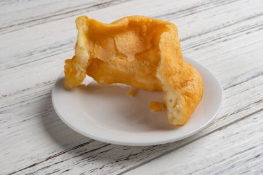 yan görünümü traditonal Çin friedcake bir ısırık beyaz tahta arka plan ile