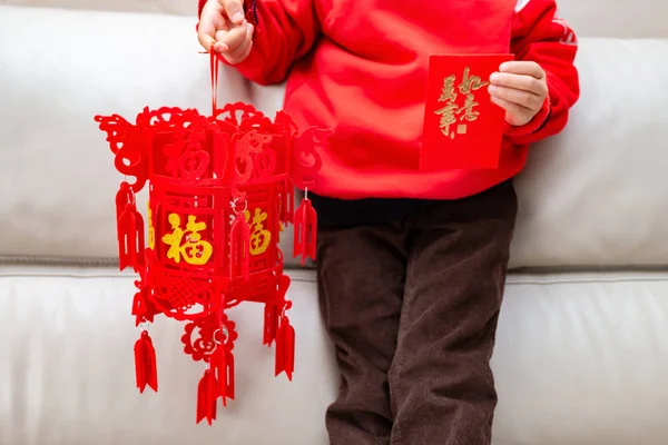 kid holding a lantern and a red pocket for Chinese New Year,words translated to English-fortune on lantern and everything is as wishes on red pocket