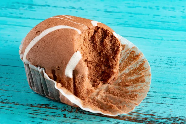 yan görünümü çikolatalı lezzet kek bazı mavi ahşap arka plan üzerinde ısırır