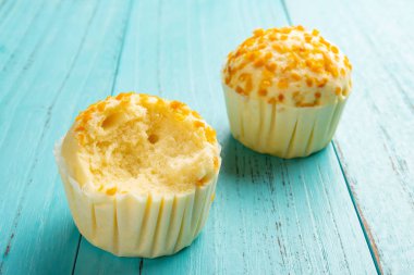 yan görünümü fincan kek tek bir ısırık ile mavi ahşap arka plan üzerinde