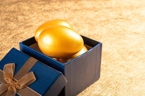 Goldene Eier Einer Geschenkbox Auf Goldenem Hintergrund — Stockfoto