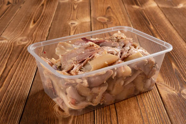 side view box of shredded boiled chicken on wood table
